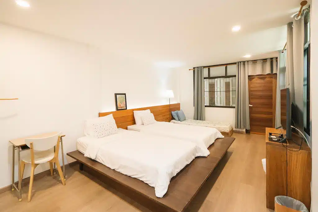 ห้องพักแสนสบายพร้อมเตียงสองเตียงและโต๊ะ เหมาะสำหรับการเข้าพักของคุณที่รีสอร์ทเชียงราย.