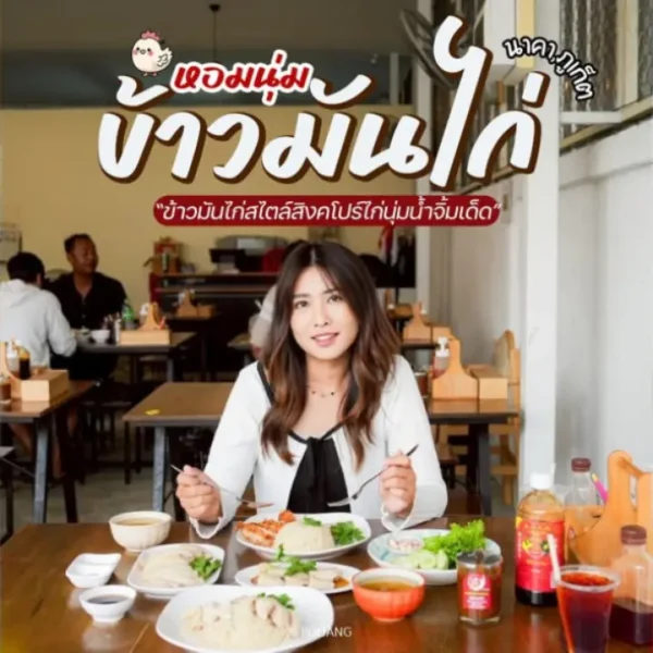 ผู้หญิงคนหนึ่งนั่งอยู่ที่โต๊ะในร้านอาหาร มีจานอาหาร ซอส เครื่องดื่ม และข้าวมันไก่สิงคโปร์ภูเก็ตอยู่ด้วย ผู้รับประทานอาหารคนอื่น ๆ อยู่ในฉากหลัง และมีข้อความภาษาไทยปรากฏบนภาพ.