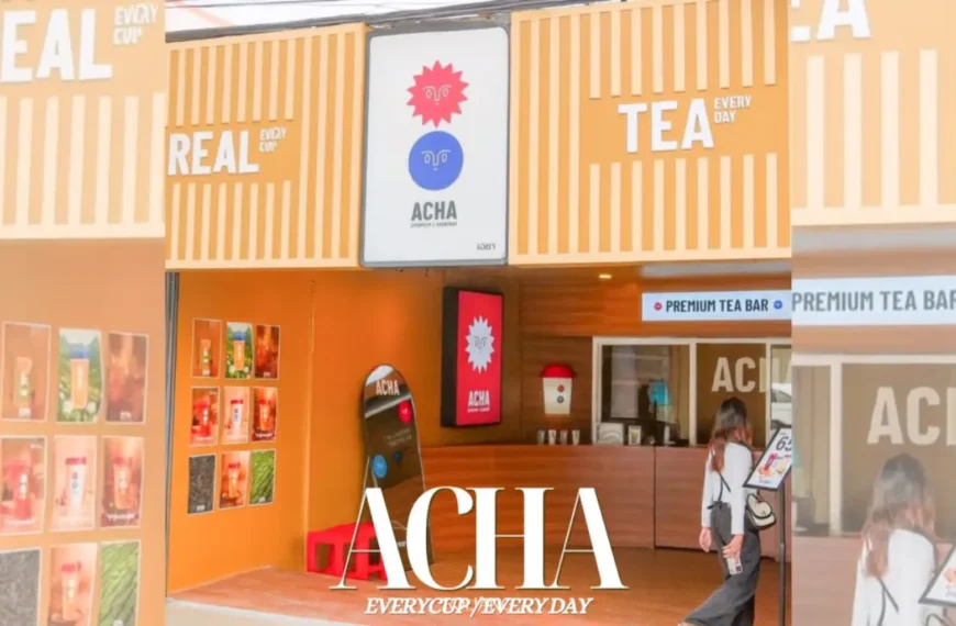 ผู้หญิงคนหนึ่งเดินเข้าไปในร้านชาที่สว่างไสวชื่อว่า ACHA ซึ่งมีผนังสีส้มและป้ายที่เขียนว่า "ชาแท้ทุกวัน" และ "บาร์ชาพรีเมียม" ซึ่งชวนให้นึกถึงร้านอาหารที่มีชีวิตชีวาซึ่งเสิร์ฟ ข้าวมันไก่สิงคโปร์ ภูเก็ต ที่อยู่ใกล้เคียง.