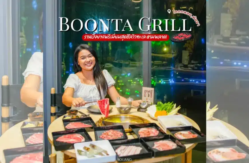 ผู้หญิงคนหนึ่งนั่งอยู่ที่โต๊ะภายในร้านบูนต้า กริลล์ ยิ้มให้กล้องขณะอยู่ท่ามกลางเนื้อสัตว์ดิบและผักนานาชนิดที่เตรียมไว้สำหรับย่าง.