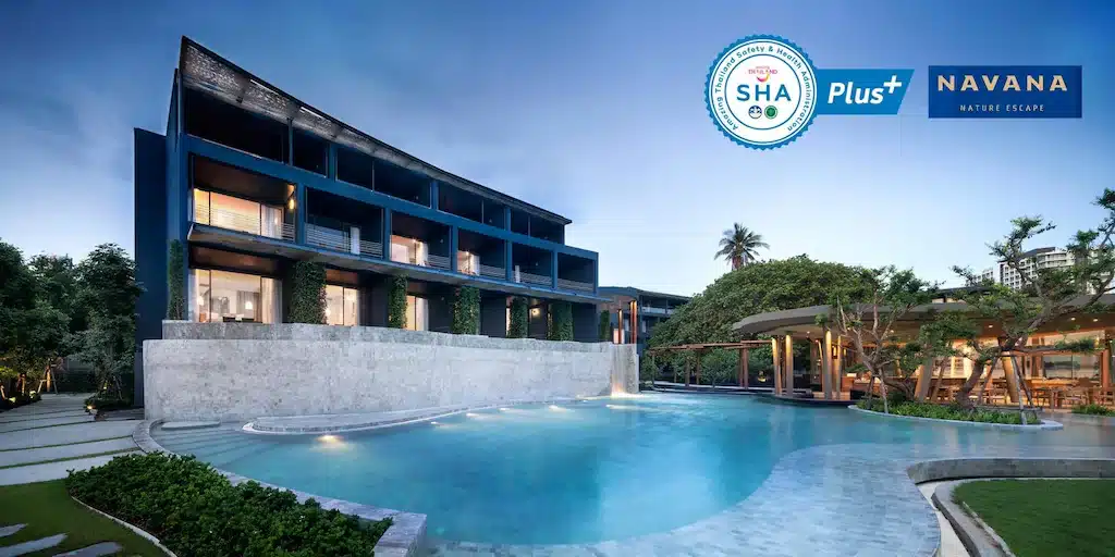 โรงแรมติดทะเลพัทยาสมัยใหม่ พร้อมสระว่ายน้ำกลางแจ้งขนาดใหญ่ ล้อมรอบด้วยธรรมชาติสีเขียวในยามเย็น มีโลโก้ SHA Plus และ Navana Nature Escape อยู่บริเวณมุม.