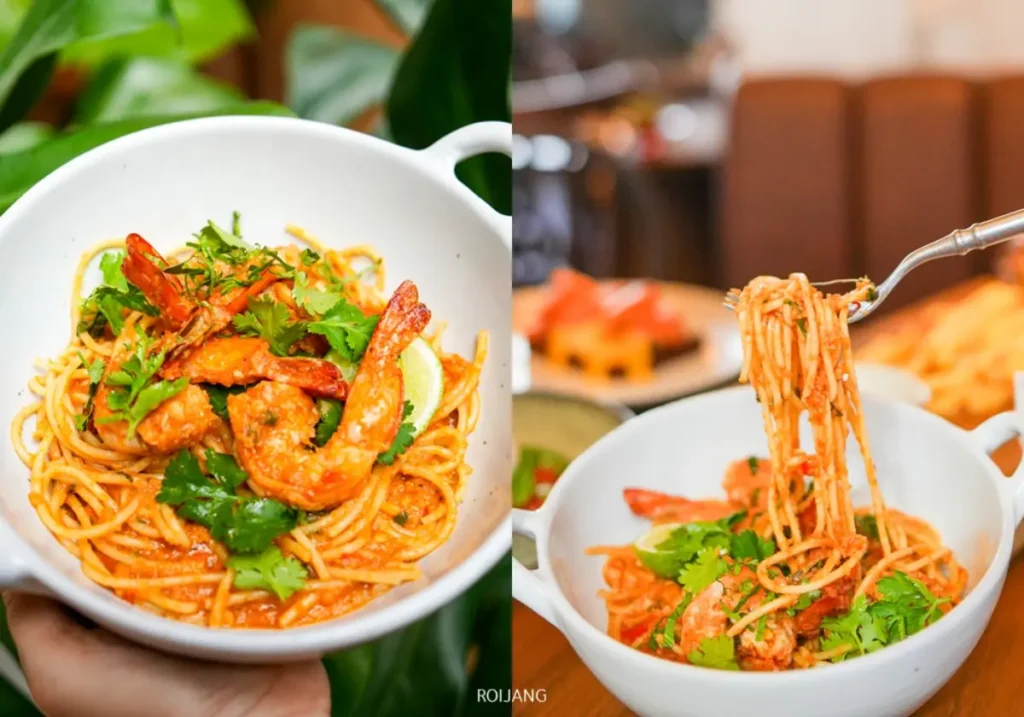 ชามสปาเก็ตตี้กับกุ้งและผักชีสดโรยหน้า แสดงให้เห็นทั้งแบบโคลสอัพและกำลังหมุนบนส้อมที่ร้าน DAY & NIGHT เชิงทะเล.