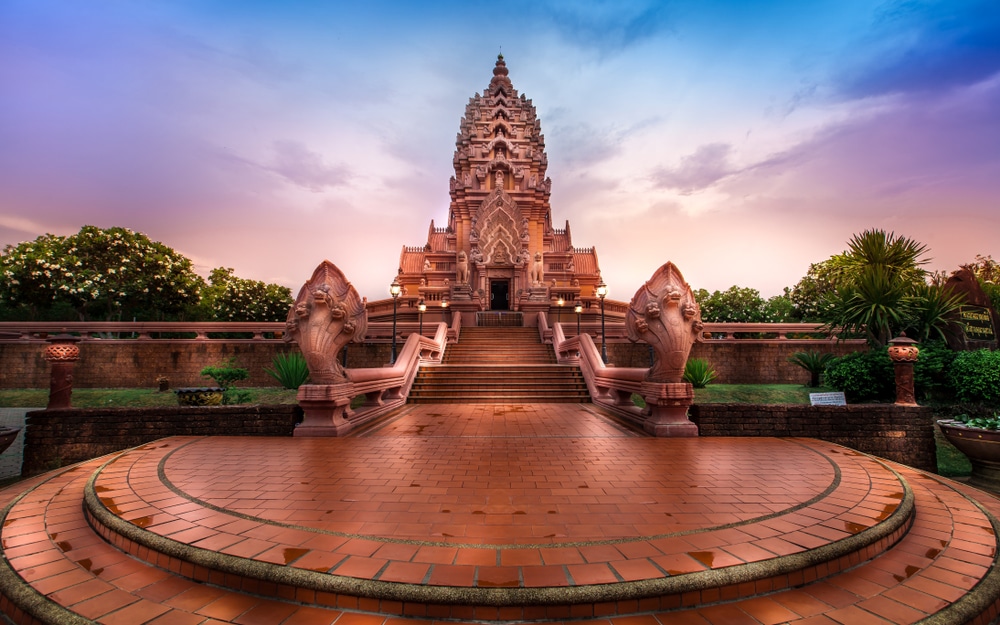 วัดที่มีลวดลายแกะสลักอย่างประณีต ประดับด้วยรูปปั้นงูอยู่ทั้งสองข้าง ตั้งตระหง่านอยู่บนยอดบันไดกว้าง ท่ามกลางท้องฟ้าสีสันสดใส—เป็นหนึ่งในสถานที่ท่องเที่ยวบุรีรัมย์ที่ไม่ควรพลาดสำหรับผู้ที่ต้องการสัมผัสมรดกทางวัฒนธรรมท้องถิ่น.