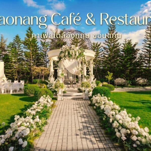 การจัดงานแต่งงานกลางแจ้งที่ร้านชาวนาง คาเฟ่ & ร้านอาหาร ประกอบด้วยศาลาสีขาว การตกแต่งด้วยดอกไม้ และการจัดที่นั่งบนสนามหญ้าสีเขียวพร้อมต้นไม้เป็นฉากหลัง.