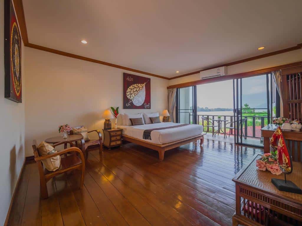 ห้องพักโรงแรมที่กว้างขวาง พร้อมเตียงขนาดใหญ่ มุมนั่งเล่น พื้นไม้ และระเบียงที่มองเห็นวิวผืนน้ำ — เป็นตัวเลือกที่สมบูรณ์แบบสำหรับนักท่องเที่ยวที่กำลังมองหา ที่พักเชียงคานราคาถูก โดยไม่ต้องเสียสละความสะดวกสบายหรือสไตล์.