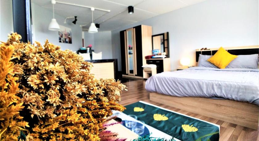 ห้องนอนพร้อมเตียงแล โรงแรมใกล้อิมแพคเมืองทองธานี ะต้นไม้ที่มุมห้อง