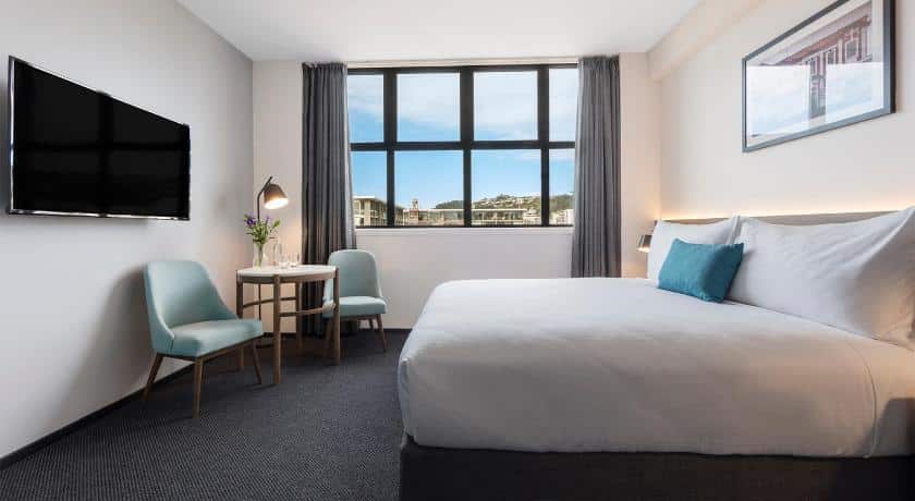 ห้องพักในโรงแรมที่มีเตียงขนาดใหญ่และทีวีจอแบน สถานที่ท่องเที่ยวนิวซีแลนด์