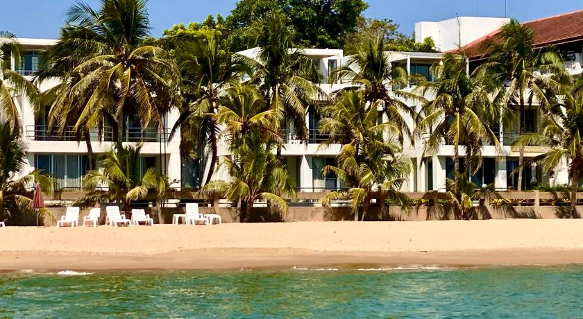 โรงแรม พูลวิลล่าระยอง ริมชายหาดที่มีต้นปาล์มอยู่ด้านหน้า
