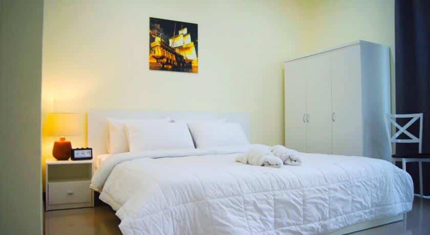 ห้อง ที่พักฉะเชิงเทรา นอนที่มีเตียงสีขาวและภาพวาดบนผนัง