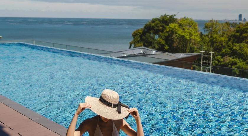 ผู้หญิง โรงแรมศรีราชาติดทะเล สวมหมวกนั่งอยู่ริมสระว่ายน้ำ