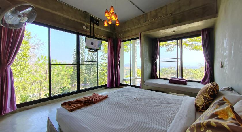 ห้องนอนพร้อมเตียงขนาดใหญ่และหน้าต่างบานใหญ่ วังน้ำเขียวที่พัก