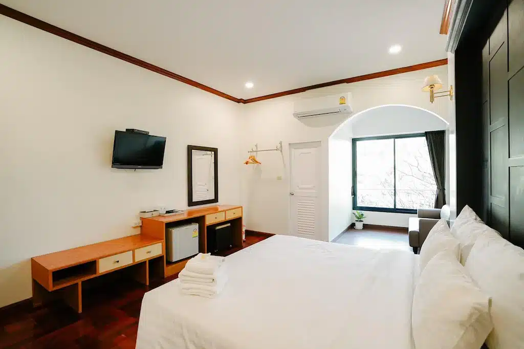 ห้องนอนพร้อมเตียงที่ทำอย่างประณีตและทีวีจอแบน ที่พักชัยภูมิ