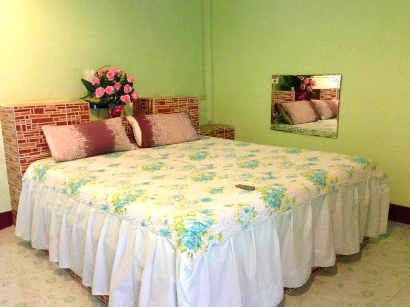 เตียงที่มี รีสอร์ทฉะเชิงเทรา ผ้าคลุมเตียงสีขาวและหมอนสีชมพู