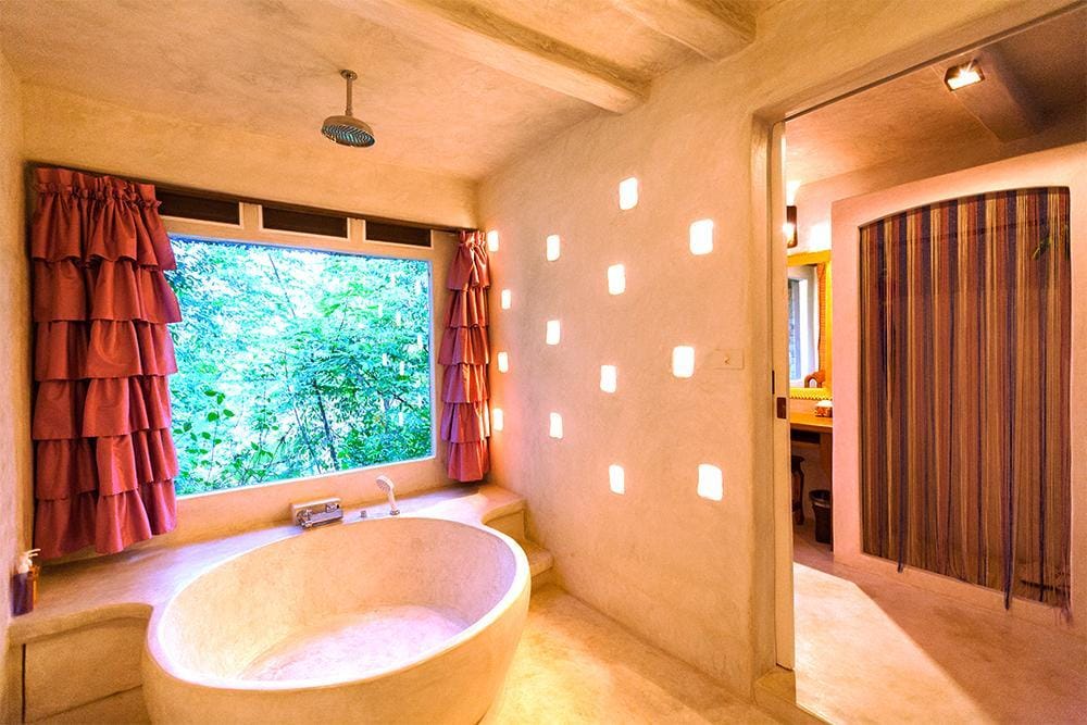 ห้องน้ำ ที่พักชัยภูมิ พร้อมอ่างอาบน้ำขนาดใหญ่และหน้าต่าง