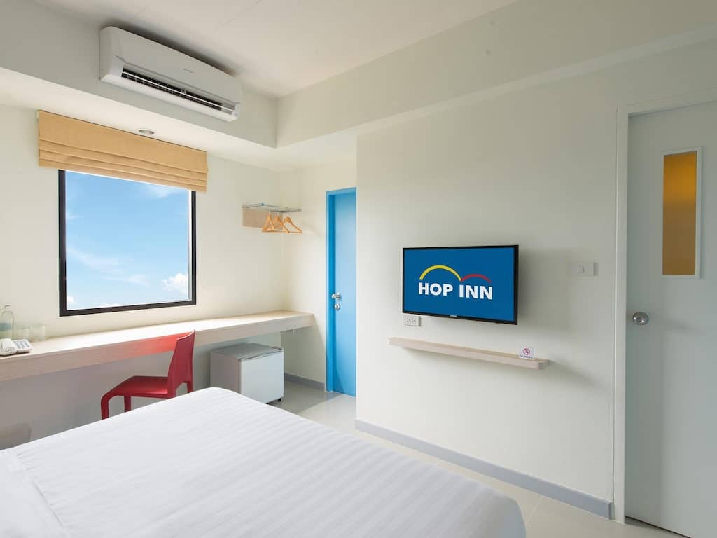 ห้องพักใน ที่พักใกล้อิมแพคเมืองทองธานี โรงแรมที่มีเตียง โต๊ะทำงาน และโทรทัศน์