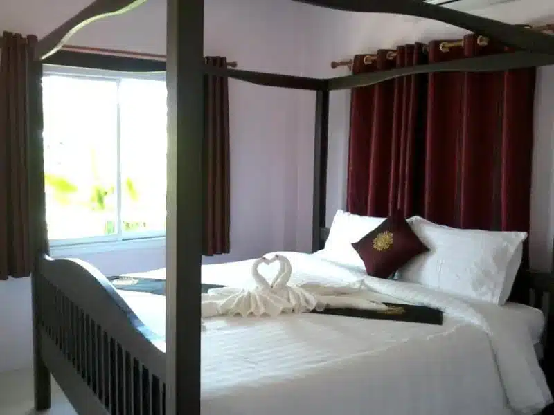 ห้อง โรงแรมในชัยภูมิ นอนที่มีเตียงสี่เสามีผ้าขนหนูปูอยู่ด้านบน