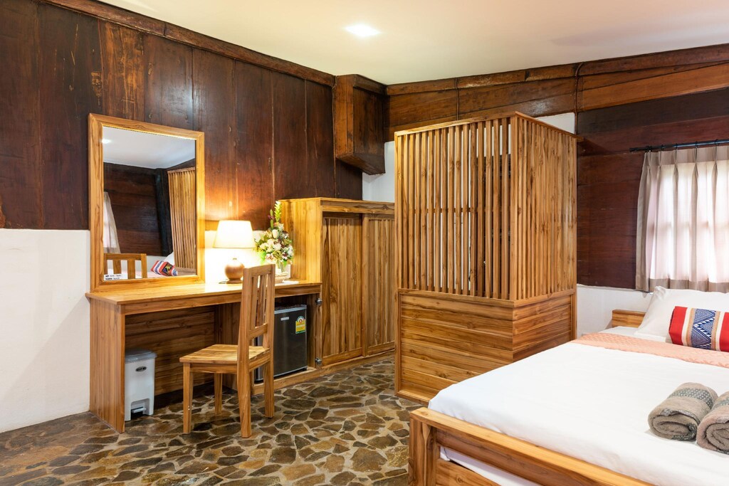 ห้องนอน โรงแรมชัยภูมิ ที่มีเตียงที่ทำขึ้นอย่างประณีตและกระจก