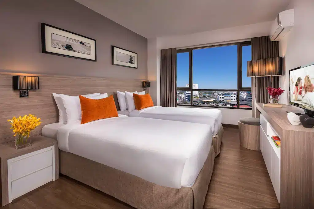 ห้องพักในโรงแรม โรงแรมศรีราชาติดทะเล ที่มีสองเตียงและทีวีจอแบน