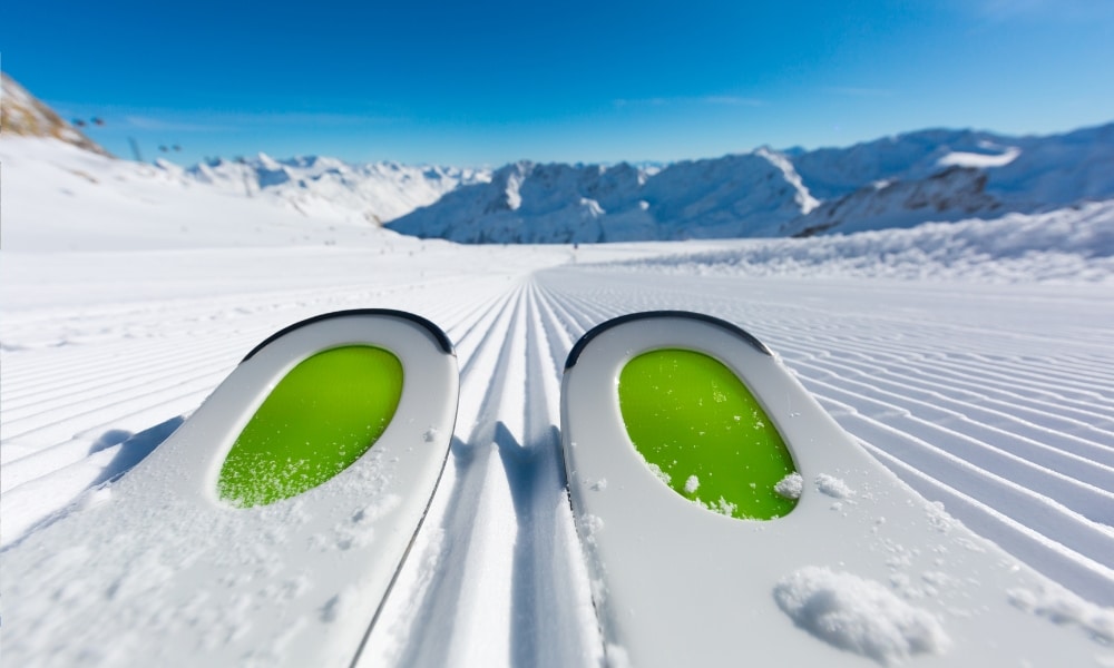 สกีคู่หนึ่ง ที่เที่ยวออสเตรีย นั่งอยู่บนเนินที่ปกคลุมด้วยหิมะ
