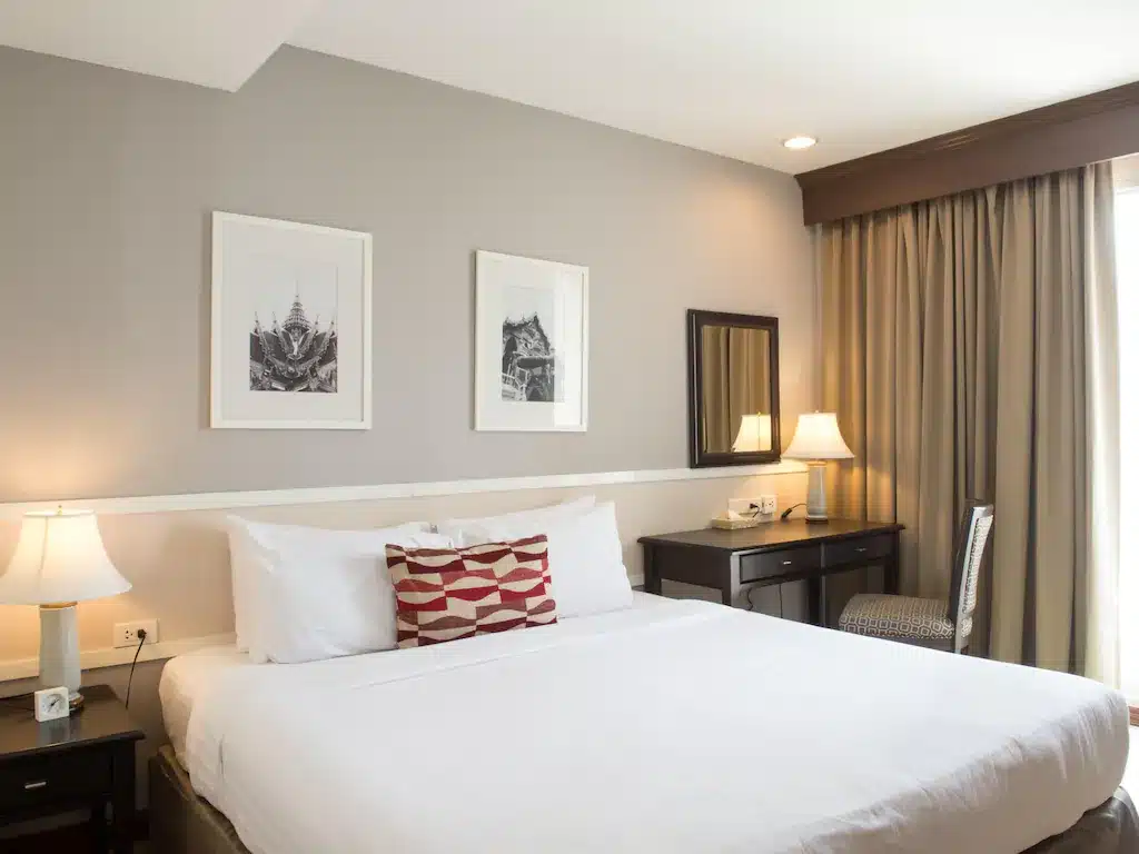 ห้องพักใน โรงแรมแถวสยาม โรงแรมพร้อมเตียงและภาพสองภาพบนผนัง