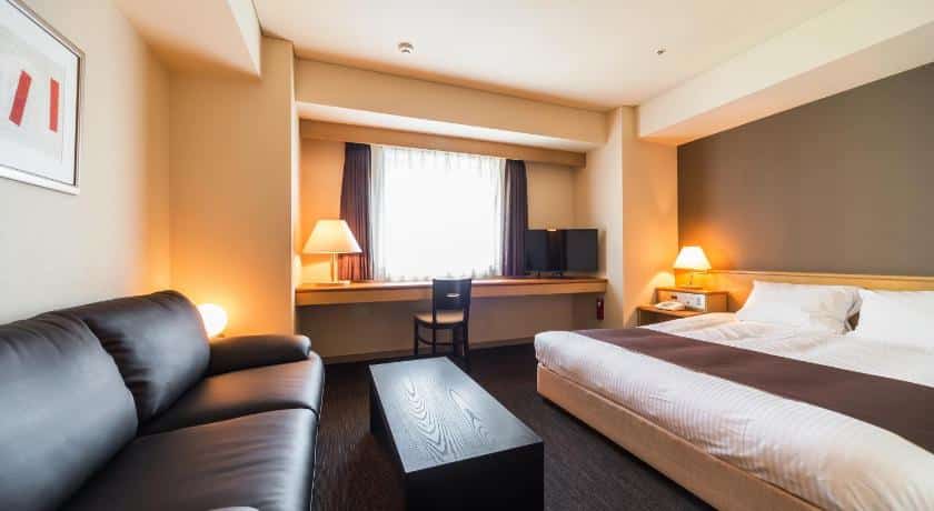 ห้องพัก ที่เที่ยวฮอกไกโด ในโรงแรมที่มีเตียง โซฟา โต๊ะ และโทรทัศน์