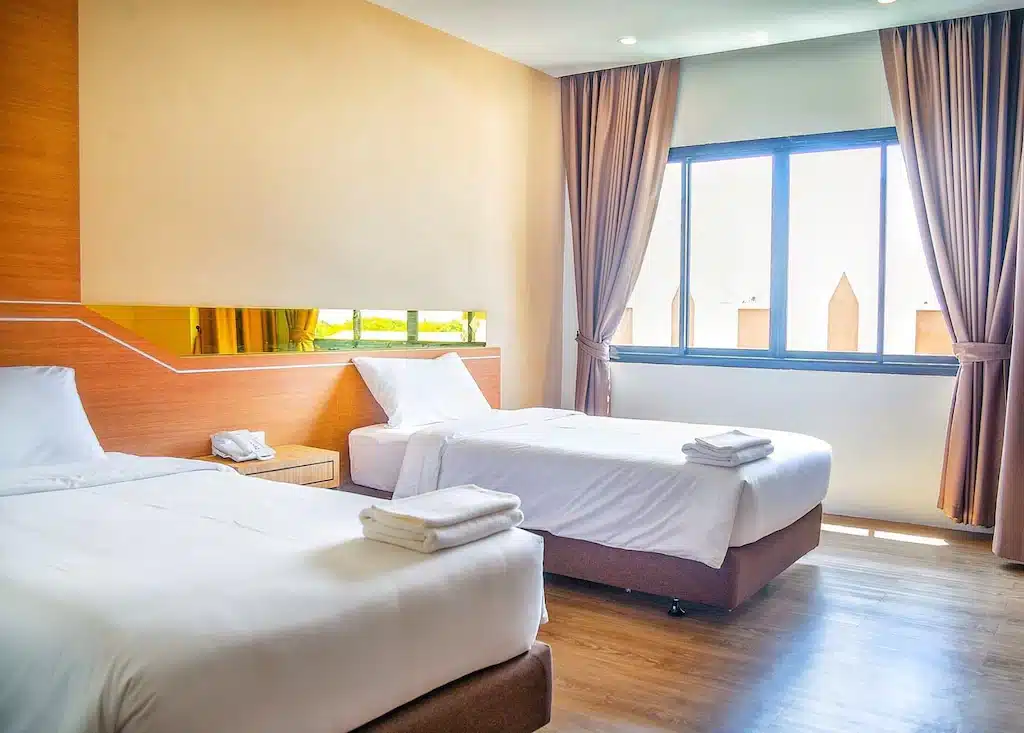 ห้องพักในโรงแรม ที่พักกันทรลักษ์ ที่มีสองเตียงและหน้าต่าง