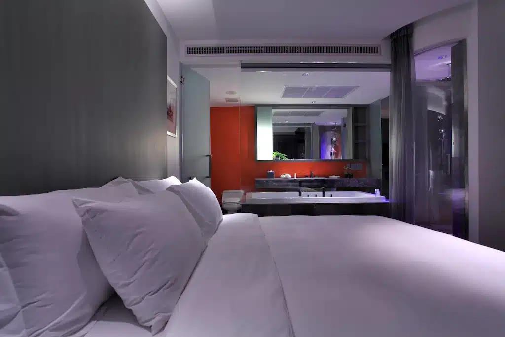 เตียงพร้อม โรงแรมแถวสยาม ผ้าปูที่นอนและหมอนสีขาวในห้อง