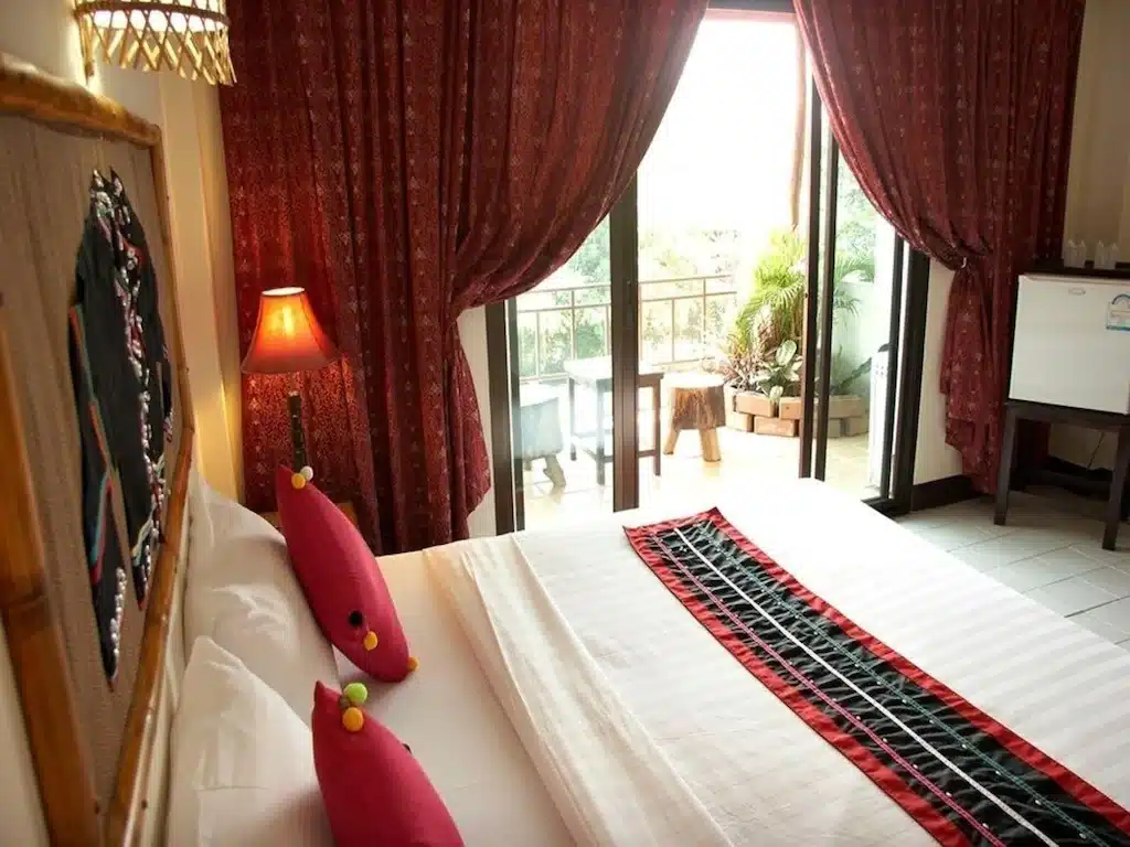 ห้องนอนที่มีเตียง ที่พักฝาง ขนาดใหญ่และผ้าม่านสีแดง