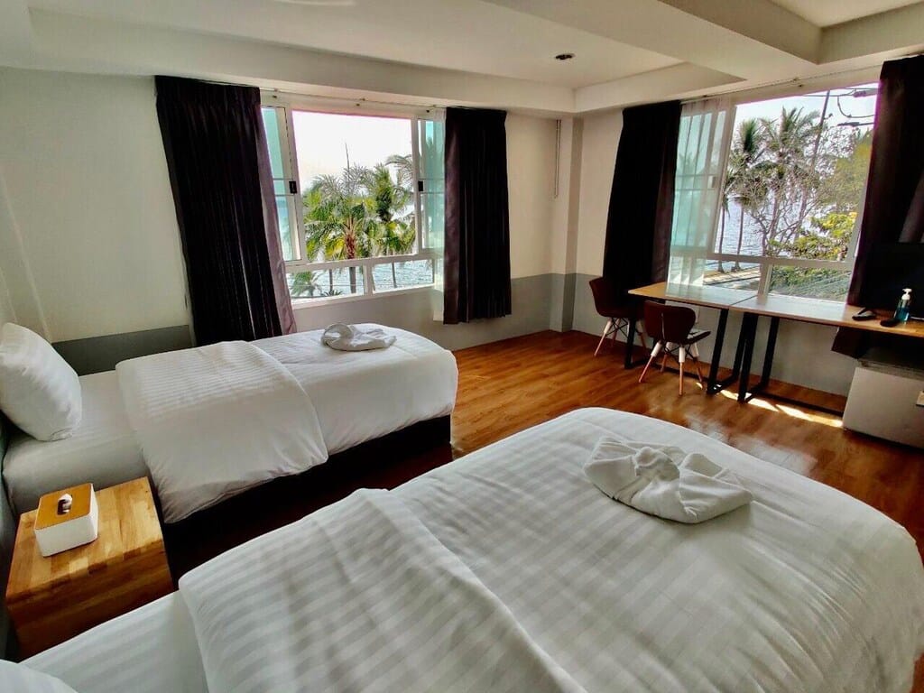 ห้องพักใน ที่เที่ยวพะเยา โรงแรมที่มีสองเตียงและโต๊ะ
