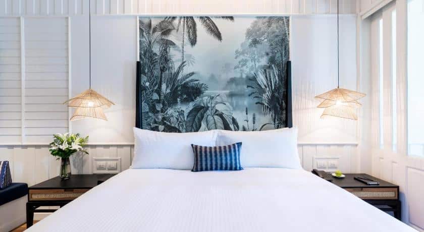 ห้องนอนที่มีเตียงสีขาวและภาพวาด ที่พักเกาะสมุย บนผนัง