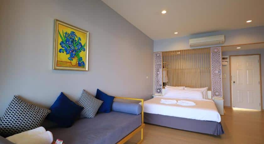 ห้องที่ ที่พักพูลวิลล่ากาญจนบุรี มีเตียง โซฟา และภาพวาดบนผนัง