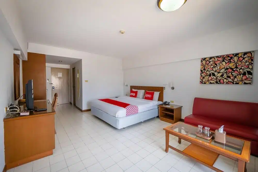 ห้องพักใน โรงแรมห้วยขวาง โรงแรมที่มีโซฟาสีแดงและเตียงนอน