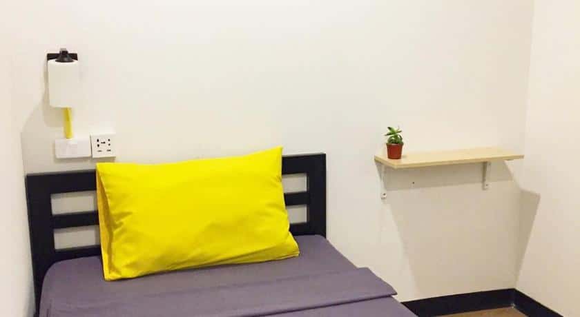 เตียงขนาดเล็กที่มีหมอนสีเหลืองวางอยู่ด้านบน ที่พักใกล้สนามบินสุวรรณภูมิ