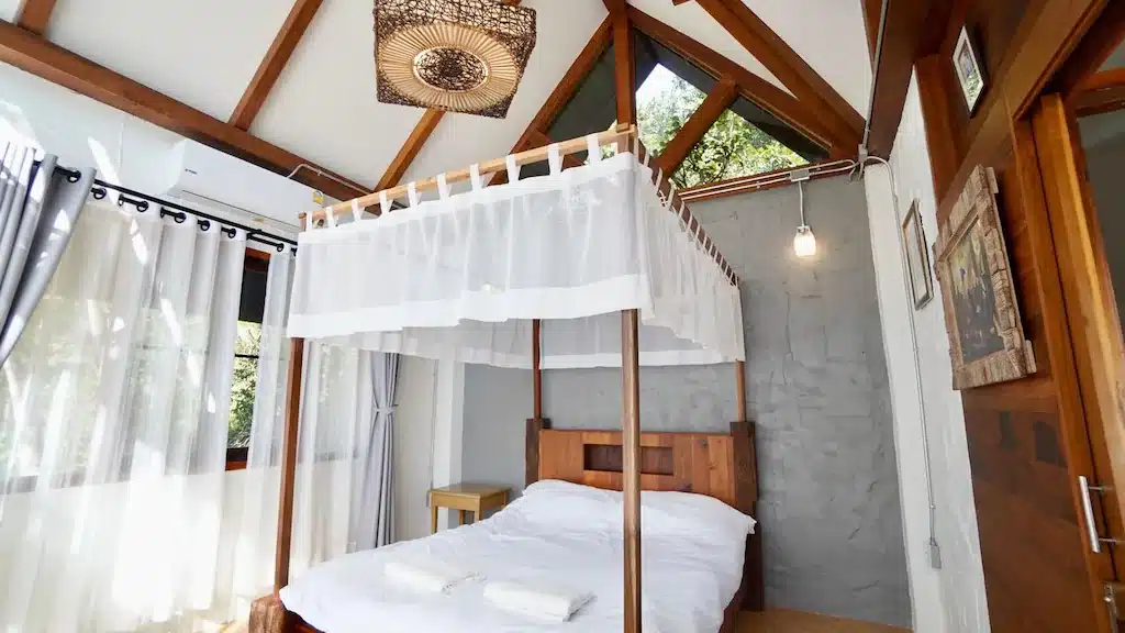 เตียงที่มีหลังคา ที่พักแม่ลาย ในห้องนอนติดกับหน้าต่าง