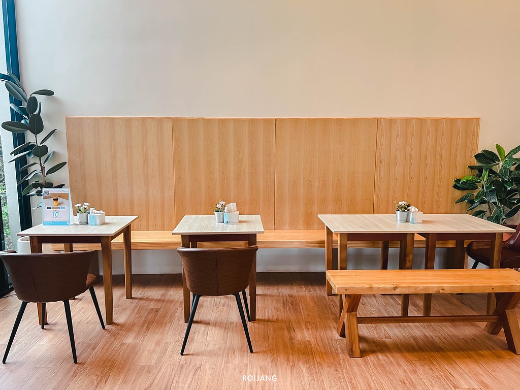 ร้านกาแฟโคกกลอย ที่มีโต๊ะและเก้าอี้ไม้และต้นไม้