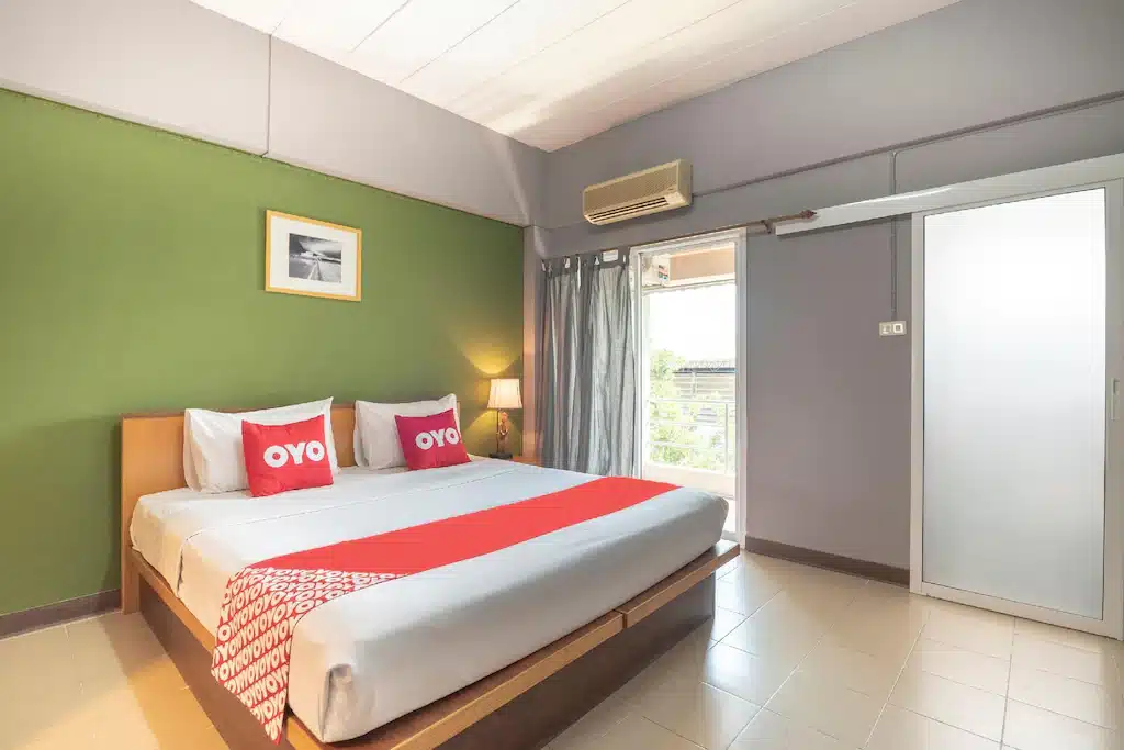 ห้องนอนที่มีผนังสีเขียวและเตียงสีขาว ที่พักใกล้สนามบินสุวรรณภูมิ