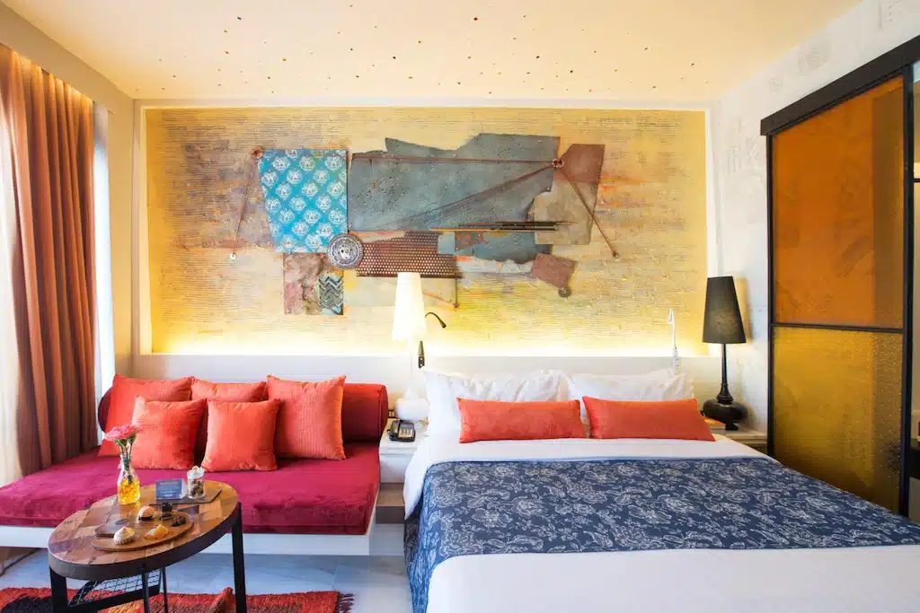 ห้อง โรงแรมแถวสยาม นอนที่มีเตียงที่ทำขึ้นอย่างประณีตและภาพวาดบนฝาผนัง