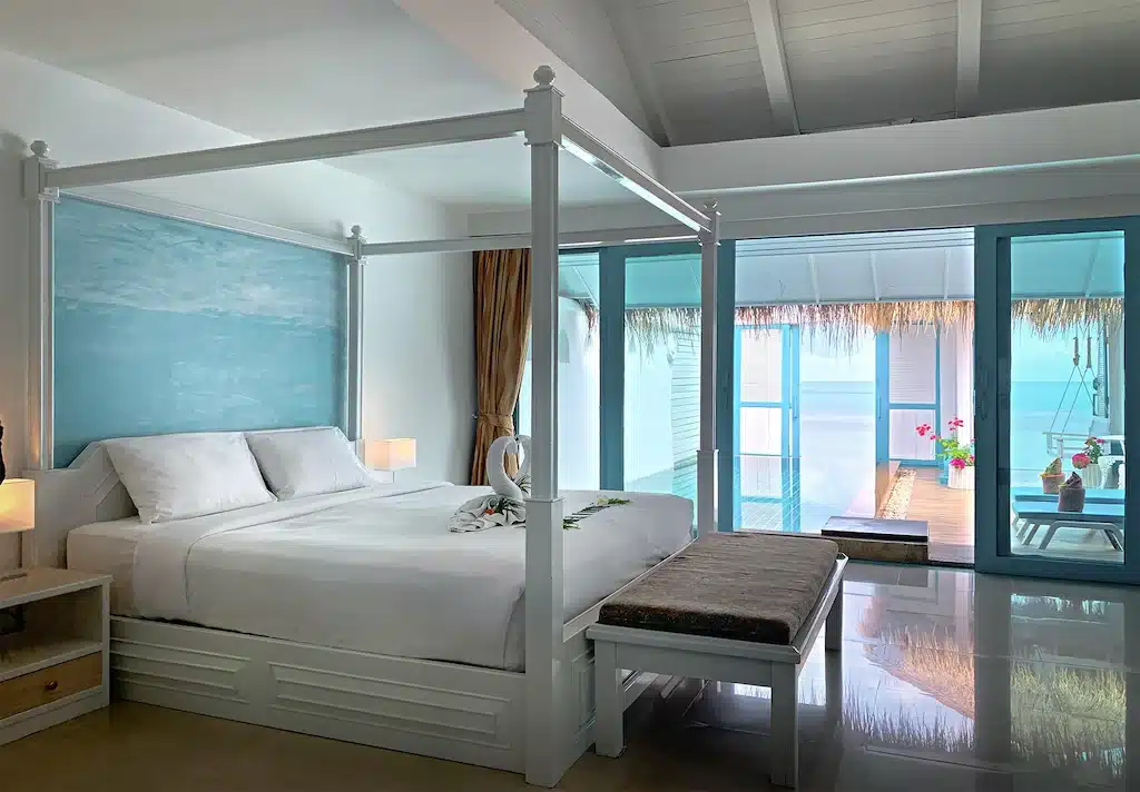 ที่พักเกาะสมุย ห้องนอนที่มีเตียงสีขาวและผนังสีน้ำเงิน