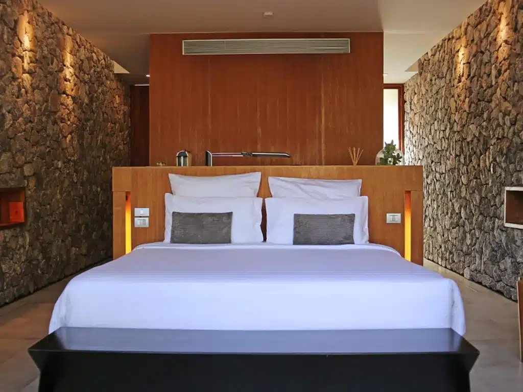 ห้องนอนที่ ที่พักกุยบุรี มีผนังหินและเตียงนอน