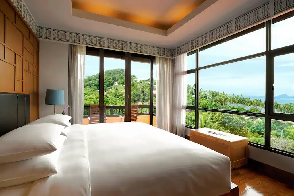 ห้องนอนพร้อมเตียงขนาดใหญ่และหน้าต่างบานใหญ่ โรงแรมสุราษฎร์ธานี