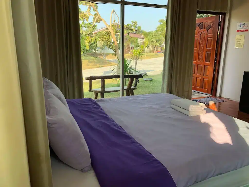 โรงแรมใกล้สนามบินสุวรรณภูมิ ห้องนอนพร้อมเตียงขนาดใหญ่และประตูกระจกบานเลื่อน