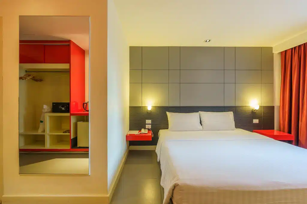 ห้องพักใน ที่พักห้วยขวาง โรงแรมที่มีเตียงและผ้าม่านสีแดง