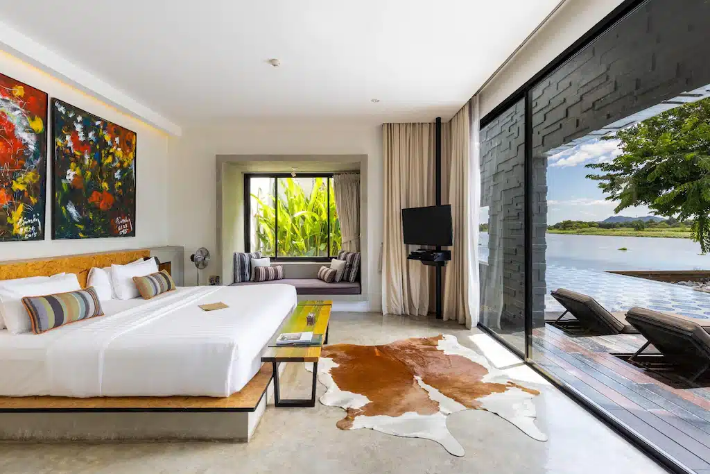 ห้องนอน พูลวิลล่ากาญจนบุรี พร้อมเตียงขนาดใหญ่และภาพวาดบนผนัง