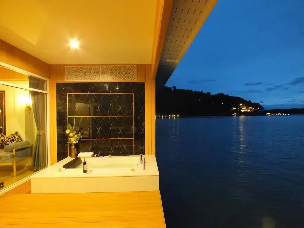 อ่างอาบน้ำ ที่พักพูลวิลล่ากาญจนบุรี ที่วางอยู่บนพื้นไม้ข้างหน้าต่างบานใหญ่