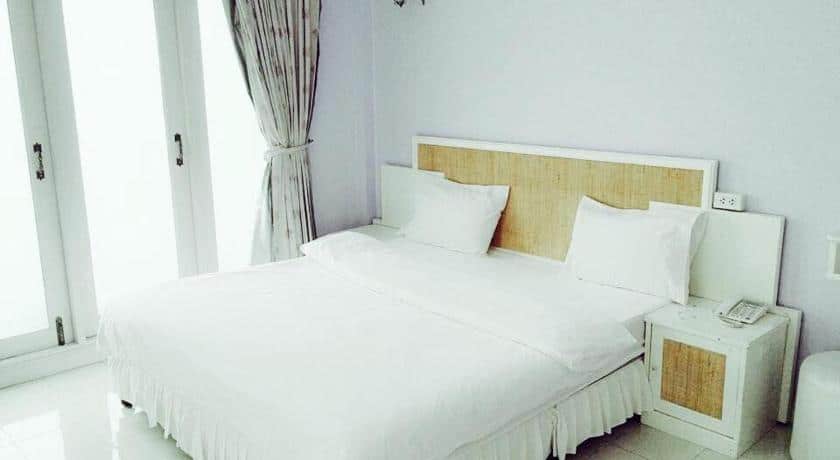 ห้องนอนที่มีเตียงสีขาวและหน้าต่าง รีสอร์ทสระบุรี