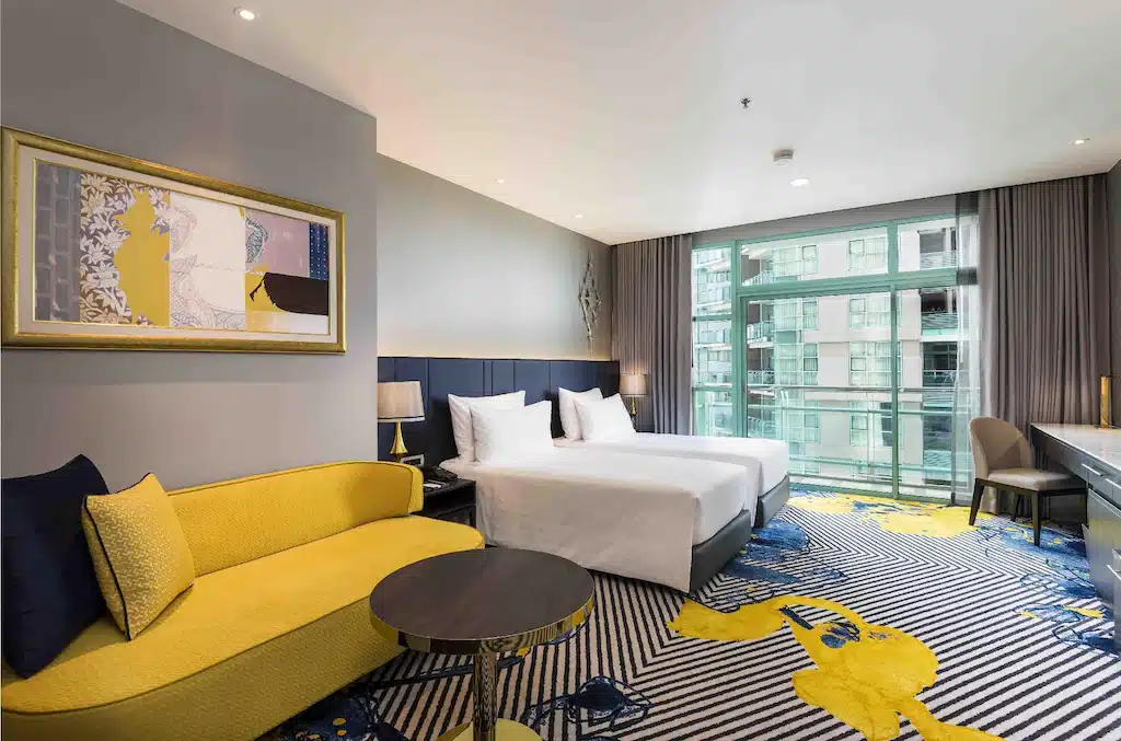 ห้องพักใน โรงแรมสยาม โรงแรมที่มีสองเตียงและโซฟาสีเหลือง