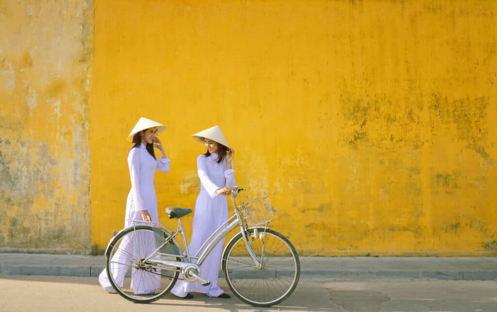 ผู้หญิงสองคนยืน ที่เที่ยวเวียดนาม ข้างจักรยาน ที่เที่ยวเวียดนาม