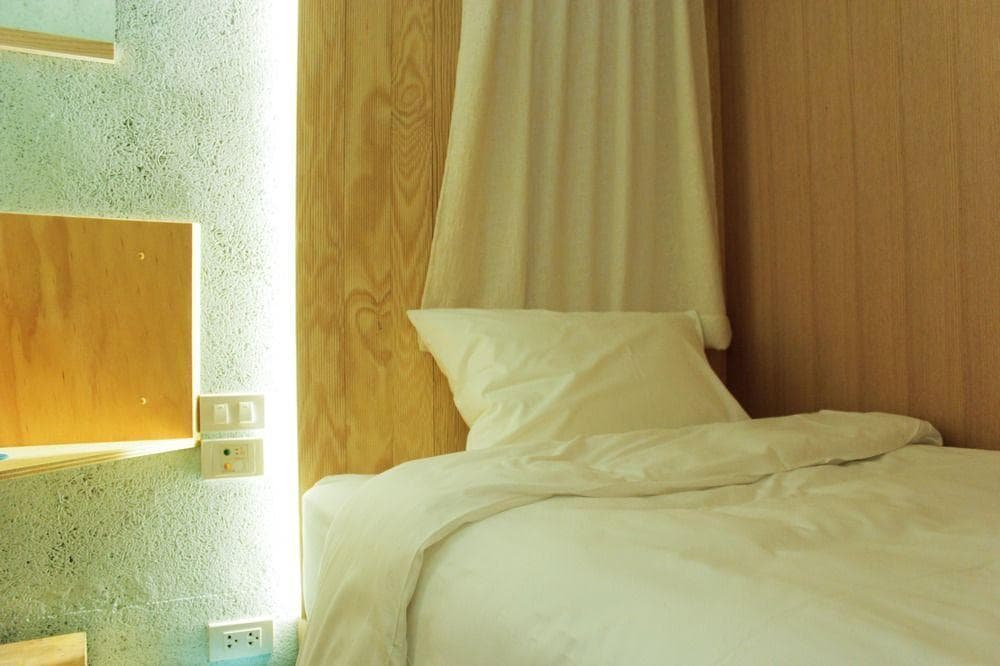 โรงแรมใกล้สนามบินสุวรรณภูมิ เตียงพร้อมผ้านวมและหมอนสีขาว