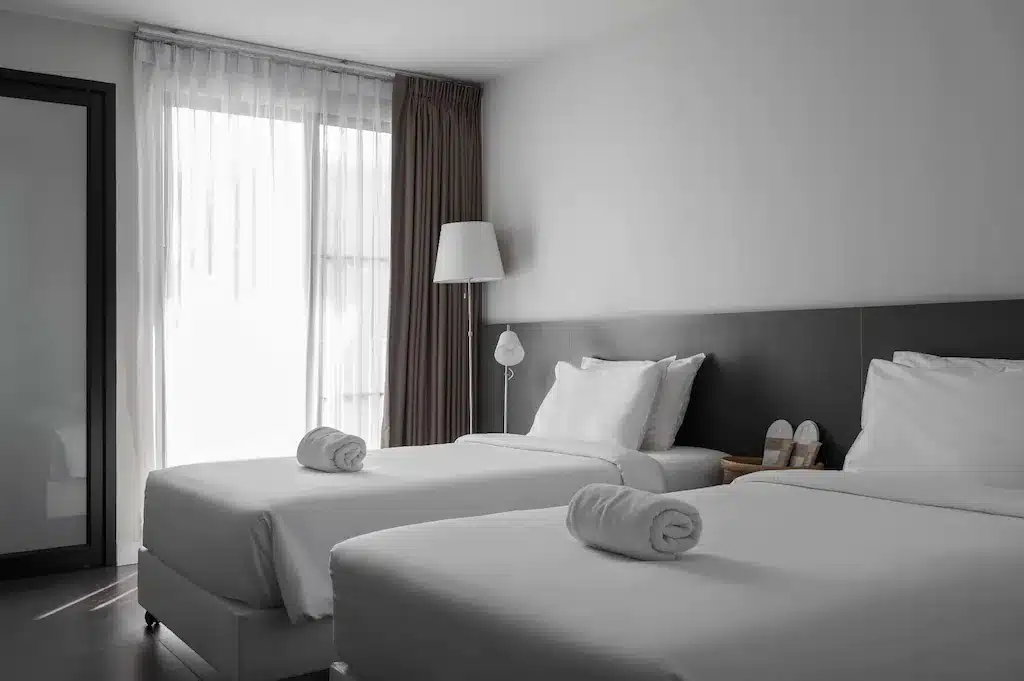 วัดพระธาตุดอยคําหลวงพ่อทันใจ ห้องพักในโรงแรมที่มีเตียงสองเตียงและผ้าเช็ดตัว