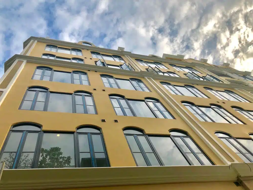 ที่พักใกล้สยาม อาคารสูงสีเหลืองที่มีหน้าต่างบานใหญ่